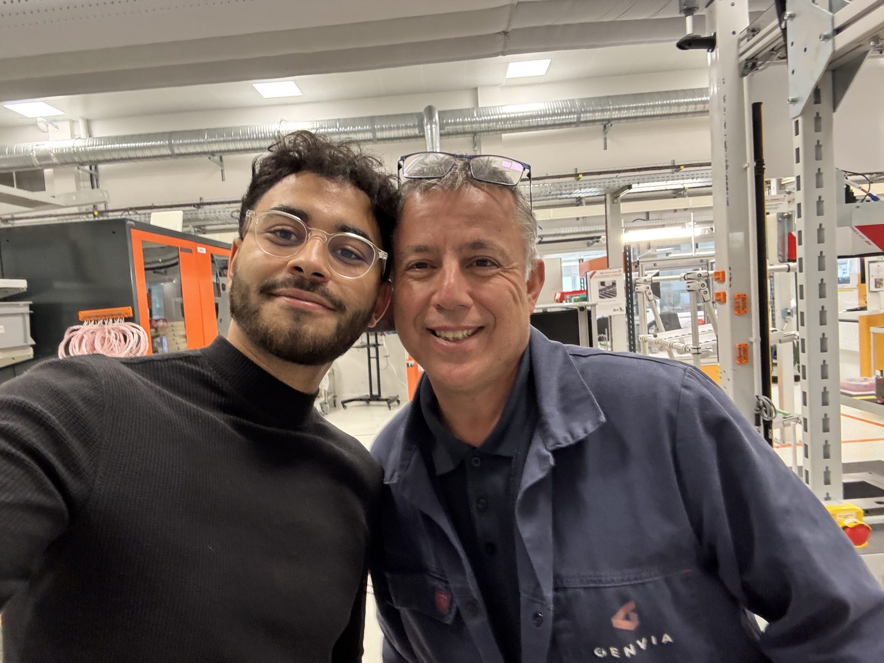 Deux collègues souriants dans le hall industriel